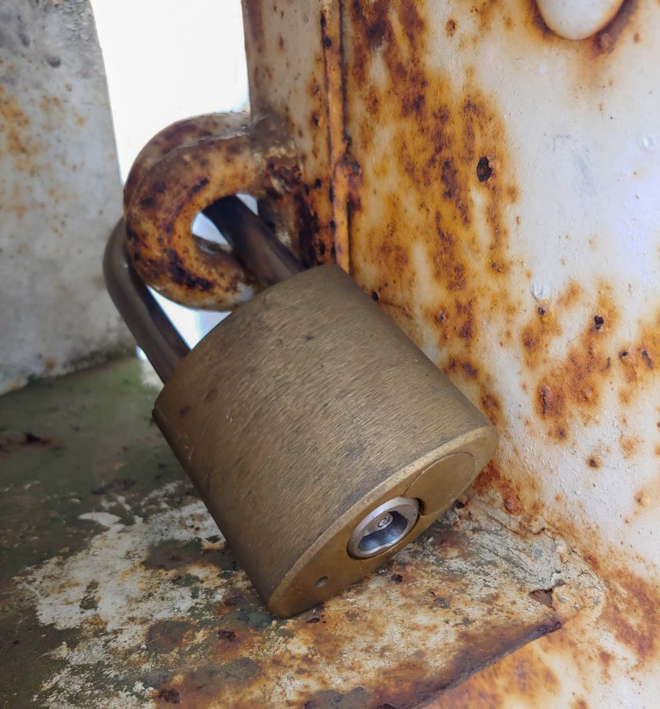 Osoba używająca smaru w sprayu do otworu kłódki